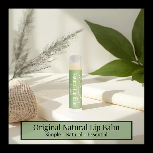 Natural lip balm on a light surface with green leaves and a woven basket in the background